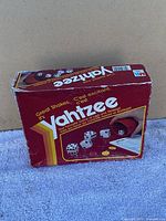 Photo of the vintage Yahtzee game box showing front with graphics of dice, cup, and score pad.