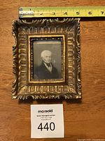 Full view of square ornate wooden frame with miniature portrait, with measuring tape showing around 5 inches width.