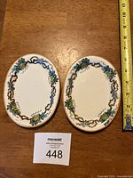 Two oval Copeland porcelain plates showing grapevine and leaf floral pattern with measuring tape for size reference.