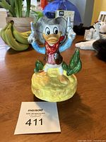 Front view of Donald Duck ceramic music figurine dressed as a cowboy.