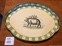 Front view showing full serving tray with pig illustration and green/cream checkerboard border.
