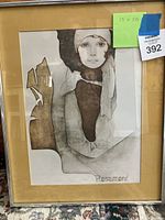 Full view of the framed artwork showing a woman’s portrait in muted colors, metal frame, beige mat, glass protected.