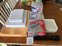 Photo showing the Sony 3.5 inch floppy disk boxes, 3M software boxes, various envelopes and Maglite flashlight on table.