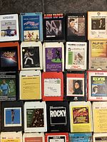 Top down photo showing a section of colorful 8-track tape cartridges with various artists and album covers including Elvis Presley and Frank Sinatra.