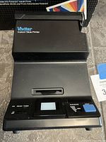 Front view of Vivitar Instant Slide Printer showing the input slot, LCD screen, exposure adjustment slider, print button, and status indicators.