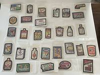 Full collection of 30 sealed Topps Wacky Packages sticker cards laid out in rows, each card showing different spoof brand labels from 1979-1980, clear protective sleeves visible.