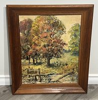Full view of the framed oil on board painting showing the autumn landscape with trees, water, and a wooden dock.