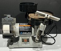Full view of Delta sharpening and grinding tool center showing grinding wheel, buffing wheel, water reservoir on top, motor housing, and switch.