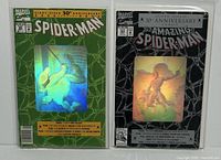 Front view of both Amazing Spider-Man comics #26 and #365 with hologram covers in protective sleeves.