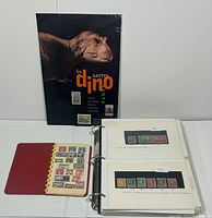 Overview: sealed dinosaur stamp booklet, red comb album open to Newfoundland stamps, 3-ring binder open to 2 pages of mounted stamps