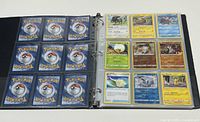 Open binder showing pages of Pokémon cards with backs and fronts visible.