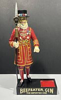 Full front view of the Beefeater Gin advertising bottle holder featuring Yeoman Warder figure on black base with brand name and bottle holder recess.
