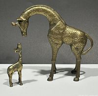 Mother and baby giraffe brass figurines side by side, showing size difference and details.