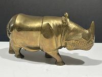 Side view of brass rhinoceros sculpture showing full body and proportions