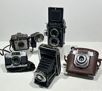 Group of five vintage cameras on white background