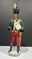 Full front view of the vintage Irish Mist soldier decanter, showing colorful details and base inscription.