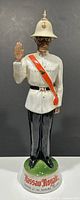 Full front view of the Nassau Royale policeman decanter showing details of the outfit and base text