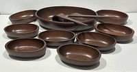 Wooden oval salad bowl set arranged front view showing large serving bowl, eight individual bowls, and two servers.