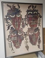 Framed wall art showing four abstract tribal faces with detailed patterns.