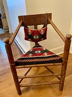 Full front view of the chair showing carved oak frame and triangular seat cushion