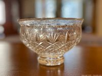 Side view of the clear crystal cut glass bowl showing detailed floral and geometric cuts on the bowl surface.