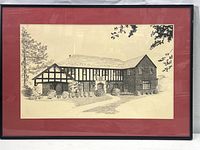 Framed etching showing Tudor style building with red mat and black frame