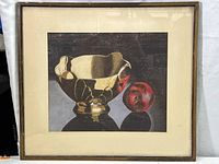 Full view of framed painting showing the gold bowl and red pomegranate against dark background.
