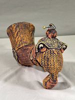 Front angled view showing orange and purple woven texture, with artistic wire detail on top.