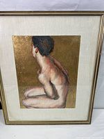 Full front view of framed painting showing nude female figure posed with back facing, gold leaf background, white mat, and gold frame.