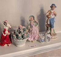 Full view of all figurines and decorative pieces including flower arrangement and small pitchers
