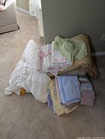 Overall group of vintage bedding and fabrics including duvet, pillowcases, fitted sheets and fabric rolls on floor