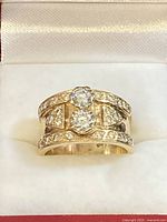 Front view showing two central round diamonds and pave-set accents on band edges