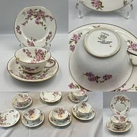 Close-up showing a teacup, saucer, and biscuit plate with floral pattern and gold trim.