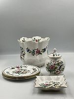 Ceramic Aynsley Pembroke dishes including three plates, covered jar, vase, and serving dish with floral design and gold trim.