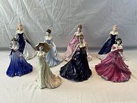 Eight figurines arranged in two rows on backdrop