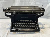 Front full view of antique Underwood typewriter showing the keyboard, front panel, and top carriage detail.