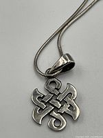 Close-up front view of the Celtic knot pendant with silver snake chain.
