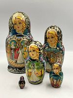 Front view of all five hand-painted nesting dolls arranged by size