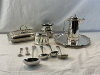 The full collection of silverplate serving items shown from front and side angles with white background.