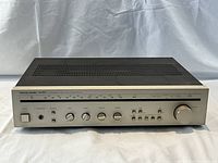 Front view of Harman Kardon HK385 stereo receiver, showing tuner dial and control knobs.