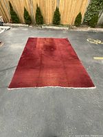 Full view of large rectangular red area rug laid flat showing size and overall color.