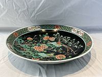 Angled interior view showing famille verte decoration on black ground