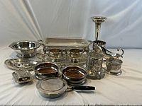 Full assortment of silver-plated serving pieces displayed on white backdrop