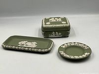 Complete set showing rectangle tray, round dish, and lidded box with decorative white relief on sage green jasperware.