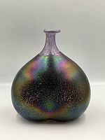 Front view of iridescent, textured hand blown art glass vase with narrow purple neck and bulbous body