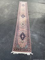 Full-length view of runner rug laid flat on asphalt