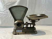 Front view of vintage computing scale with dial and metal weighing pan, showing overall item condition and details.