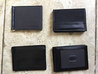 Top-view photo showing four slim black men's wallets arranged on tile floor, displaying front side of each wallet.