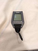 Front view of the Bushnell BackTrack GPS unit showing blank screen and carabiner.