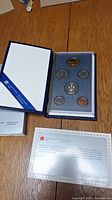 Display box open showing all six coins in presentation holder with certificate and cover.